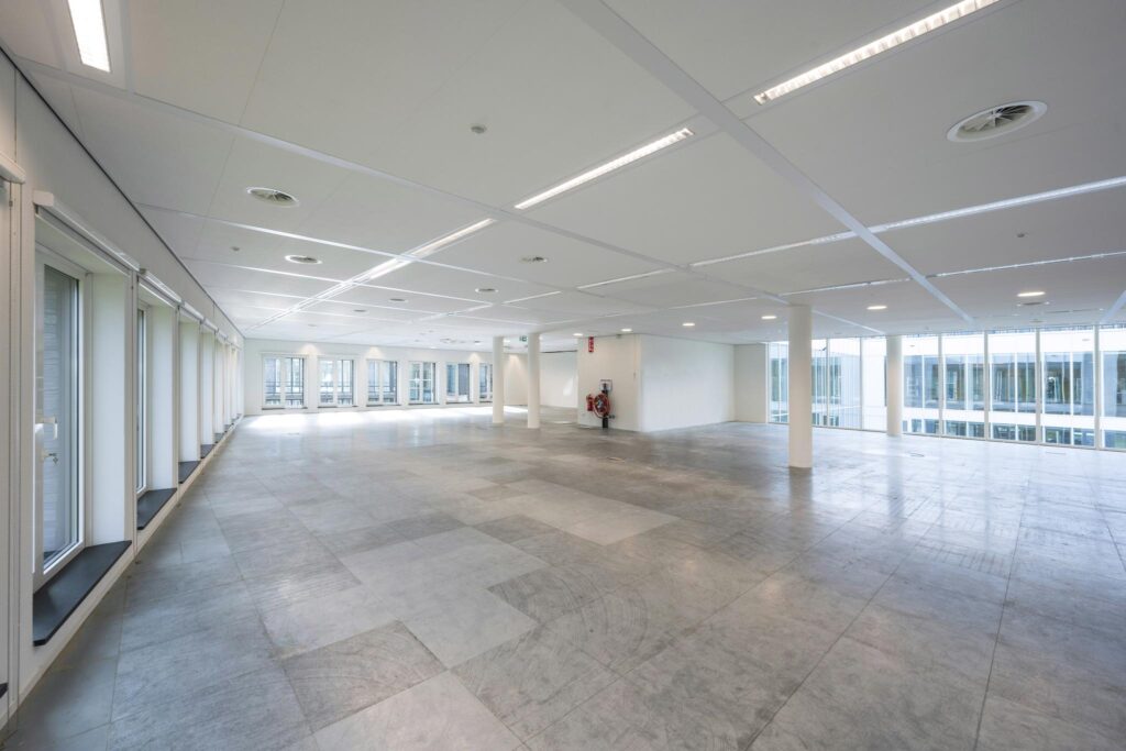 Ruime, lege kantoorruimte aan de De Cuserstraat met grote raampartijen en systeemplafond.